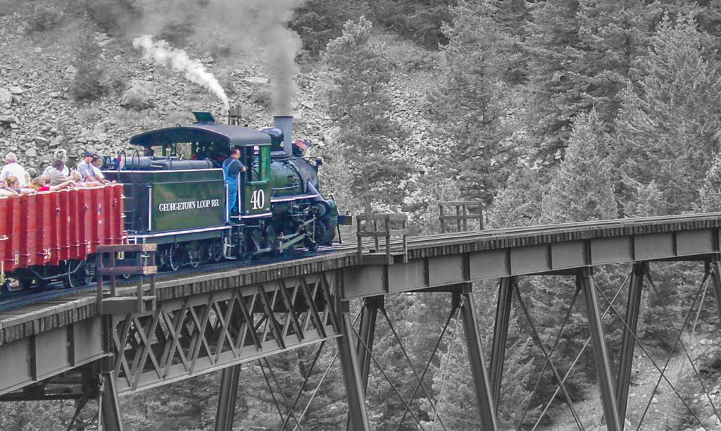  A colorful train on a narrow curving bridge 
