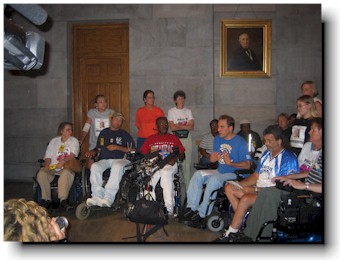 About 20 activists hold a press conference in the capitol.